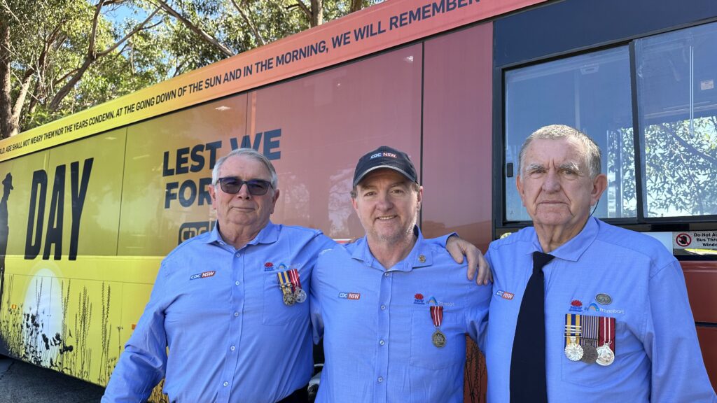 Veteran bus drivers standing in front of a CDC NSW bus